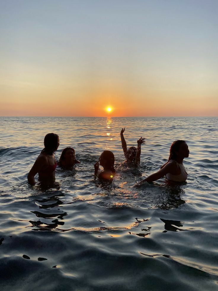A group of friends laughing and dancing through the waves.